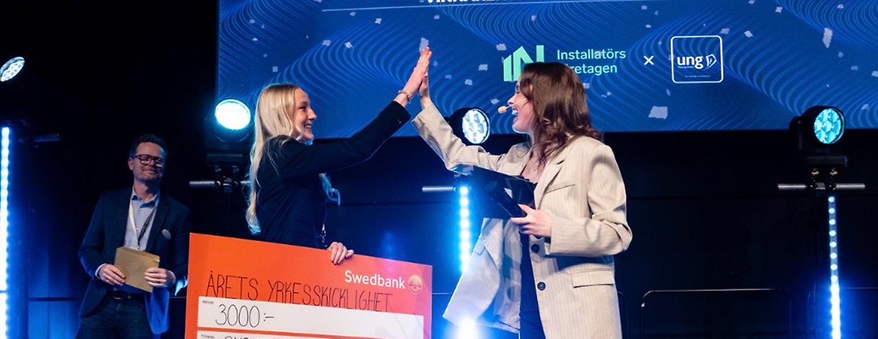 Wilma tar emot sitt pris och ger en high five till moderatorn.