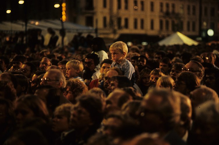 Bild på publik under Malmöfestivalen. På bilden syns ett. hav av människor med ett litet barn som sitter på någons axlar i förgrunden. 