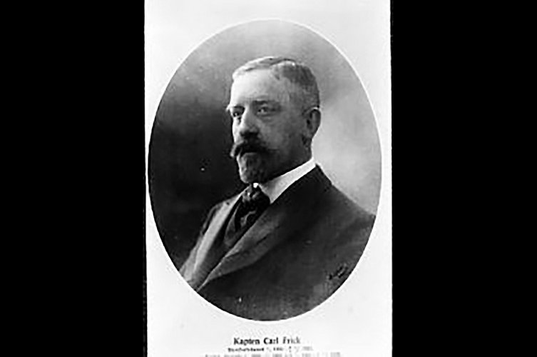 Svartvitt porträtt av man med mustasch.
