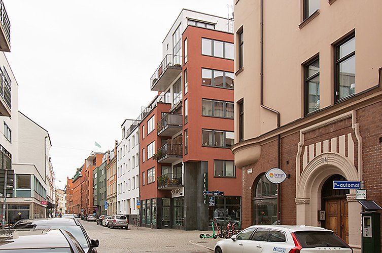 Kullerstensgata med både älder flerfamiljshus från sekelskiftet och moderna hus från 2000-talet. 