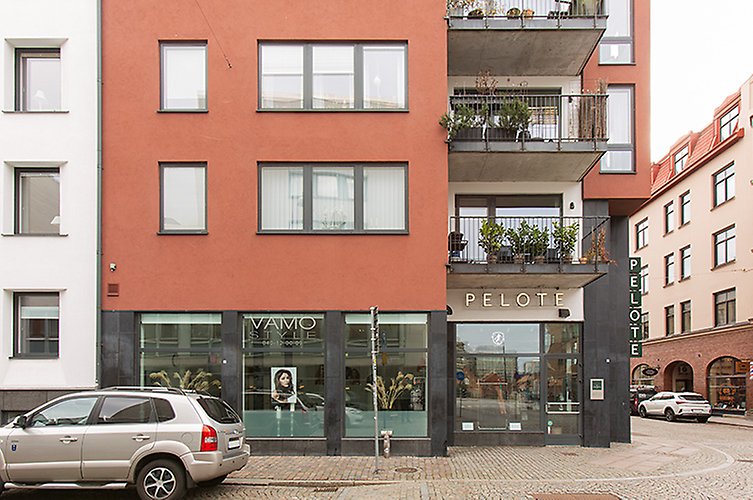 Modernt flerfamiljshus med balkonger och restauranglokal i bottenplan. 