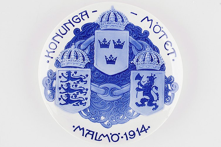 Sveriges, Norges och Danmarks riksvapen samt texten "Konungamötet Malmö 1914" på porslinsfat.