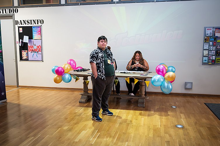 Artist som är på väg upp på en scen. Scenarbetare tar emot.