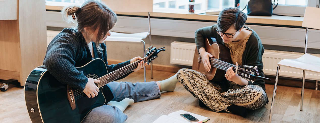 Emelie Grankvist och Renée Anderberg, studenter på förskollärarutbildningens musikprofil, provar att spela Arne Alligator med olika slags gitarrkomp.